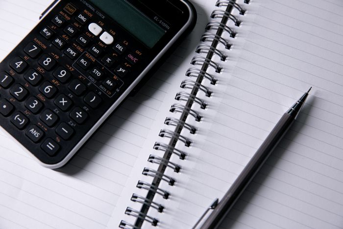 Rekenmachine, geopend notitieboek en pen voor het controleren van fiscale cijfers